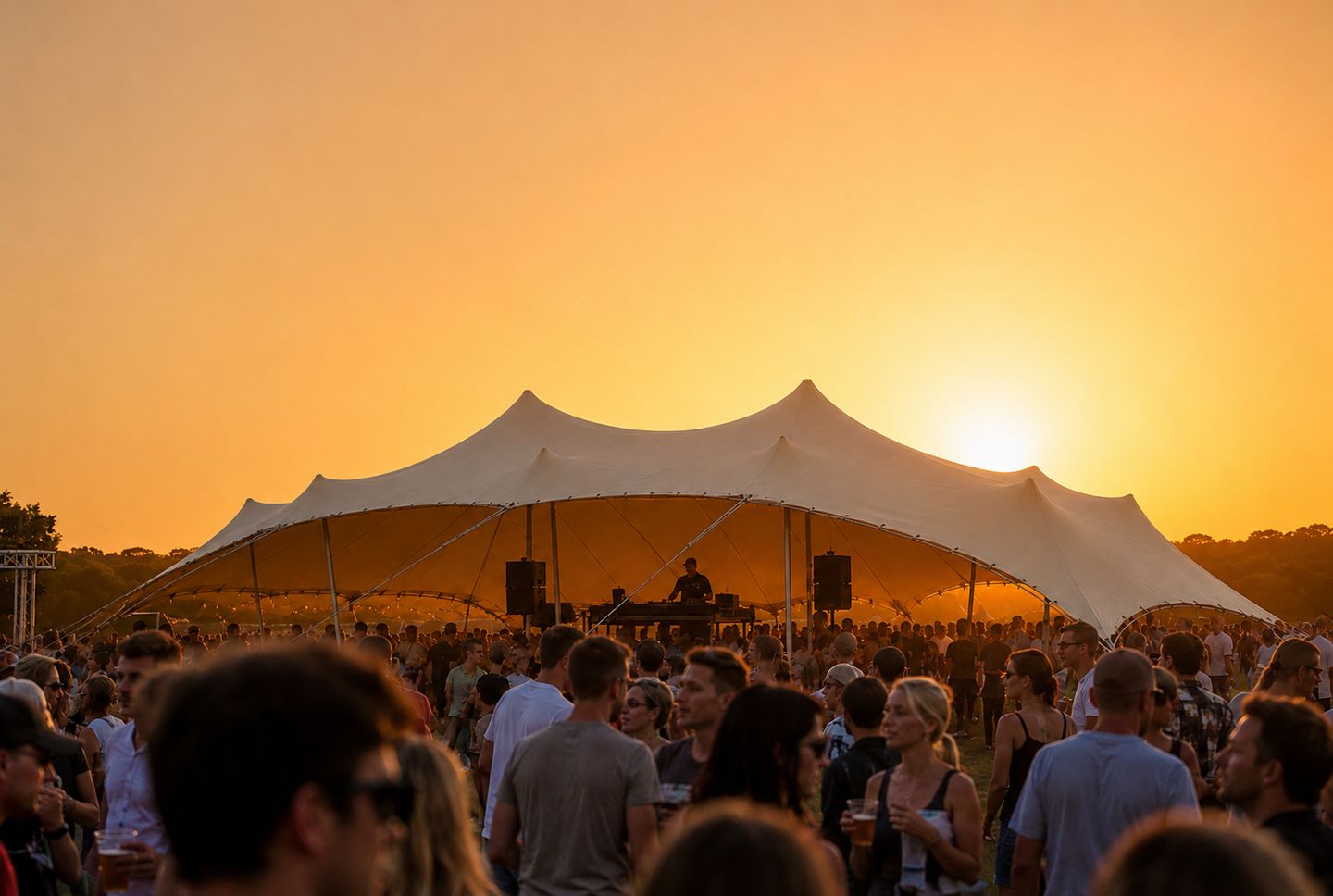 Crowd gathered beneath a large Bedu tent at sunset